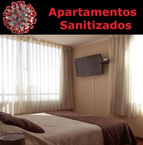 a bedroom with a bed and a flat screen tv at Personal Aparts Bellas Artes in Santiago