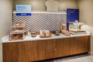 a counter with a variety of pastries on it at Holiday Inn Express & Suites Chicago-Midway Airport, an IHG Hotel in Bedford Park