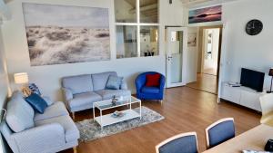 a living room with two couches and a tv at Henåns Hostel in the Marina in Henån