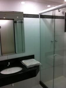 La salle de bains est pourvue d'un lavabo et d'une douche en verre. dans l'établissement Hotel Encontros (Adult Only), à Rio de Janeiro