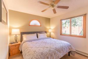 a bedroom with a bed with a ceiling fan and a window at Woodlands on Fall River in Estes Park