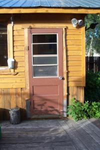 eine Tür zu einem kleinen Haus mit einer Veranda in der Unterkunft Cabine, Home Sweet Home in Whitehorse