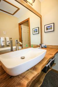 een badkamer met een witte wastafel en een spiegel bij Woodlands on Fall River in Estes Park