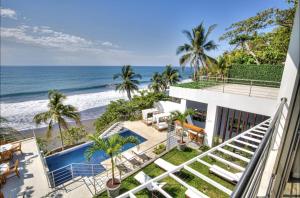 a view of the beach from the balcony of a house at Garten Hotel in El Zonte