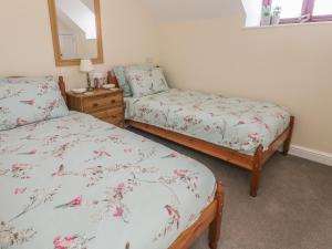 a bedroom with two twin beds and a mirror at Ash Cottage in Llandysul