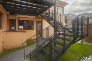 a staircase leading up to a house with mountains in the background at Departamentos La fe in Ushuaia