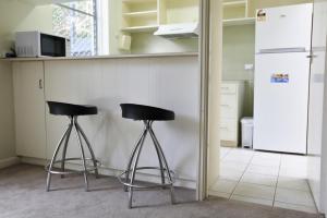 two black stools in a kitchen with a refrigerator at Downstairs in Hawthorn in Melbourne