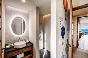 
a bathroom with a sink, mirror, and toilet at Palmaïa - The House of AïA Wellness Enclave All Inclusive in Playa del Carmen
