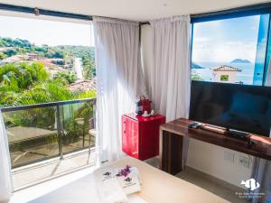 een kamer met een groot raam met uitzicht op de oceaan bij Pousada Praia João Fernandes in Búzios