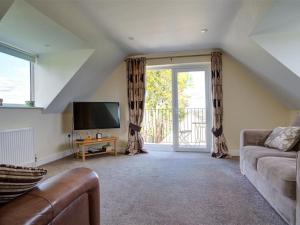 uma sala de estar com um sofá e uma televisão em The Cartins em Stroud