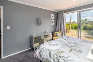 a bedroom with a bed and a sliding glass door at Fern Haven in Martinborough 