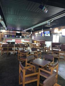 ein Esszimmer mit Tischen, Stühlen und Tischtennisplatten in der Unterkunft Bar-B Inn in Assiniboia