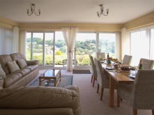 a large living room with a table and a couch at Gull's Rest in Seaton