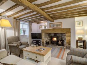 a living room with a fireplace and a table at Sunnyside Cottage in Bampton