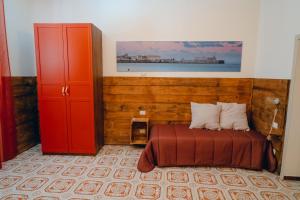a bedroom with a bed and a red cabinet at SyracuseApartments il mare di Ortigia in Syracuse