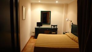 sypialnia z łóżkiem, biurkiem i lustrem w obiekcie Hotel El Volao w mieście Villanueva de Córdoba
