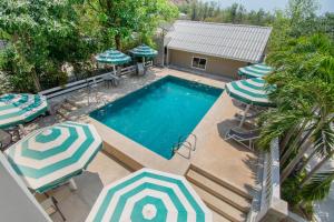 an overhead view of a swimming pool with umbrellas at OYO 765 Pom Pom Residence in Hua Hin