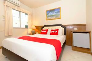a bedroom with a large bed with red pillows at OYO 765 Pom Pom Residence in Hua Hin