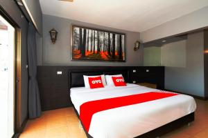 1 dormitorio con 1 cama grande con almohadas rojas en OYO 765 Pom Pom Residence, en Hua Hin