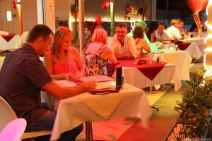 a group of people sitting at a table in a restaurant at Ramada by Wyndham Hervey Bay in Hervey Bay