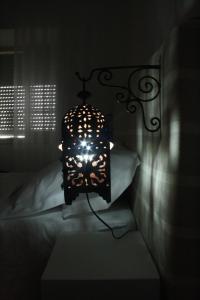 a lamp in a dark room with a bed at Bora Dormir in Lagos