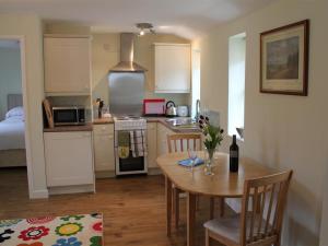 a kitchen with a table and a kitchen with a bed at The Tractor Shed in Shaftesbury