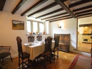 a dining room with a table and chairs and a kitchen at Tumbledown in Broadway