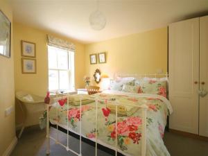 een slaapkamer met een bed met bloemen erop bij Garden Cottage in Alvescot