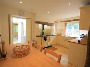 a large kitchen with a wooden table and a dining room at The Lodge in Quenington