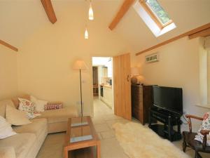 a living room with a couch and a flat screen tv at The Lodge in Quenington