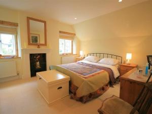 a bedroom with a bed and a fireplace at The Lodge in Quenington