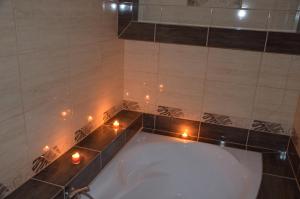 卡克特采的住宿－帕拉丁旅館，浴室配有带蜡烛的浴缸。