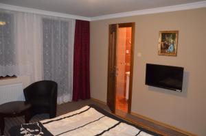 a hotel room with a bed and a flat screen tv at Palatín in Čachtice