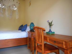 a bedroom with a desk and a bed and a desk with a chair at Eko Homestay in Sidemen