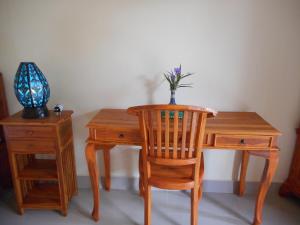 a wooden desk with a chair and a vase with a plant at Eko Homestay in Sidemen +17 photos