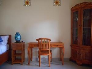 een slaapkamer met een bureau, een stoel en een bed bij Eko Homestay in Sidemen