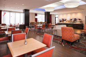 Un restaurante con mesas y sillas y una cafetería. en Holiday Inn Express & Suites Monroe by IHG, en Monroe