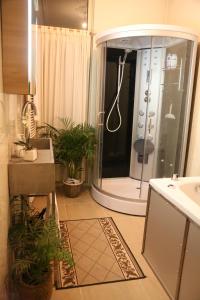 y baño con ducha, lavabo y plantas. en Antonius Bed and Breakfast, en Arnhem