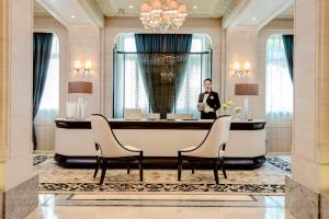 a man in a tuxedo standing in front of a desk at Sofitel Legend People's Grand Hotel Xi'an in Xi'an