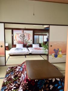 Cette chambre comprend un lit et une table. dans l'établissement 天ゆふ(Ten Yufu), à Yufu