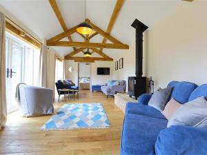 uma sala de estar com um sofá azul e uma lareira em Park Stables em Wyck Rissington