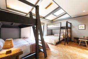 1 dormitorio con 2 literas y escritorio en Riverside Lodge, en Matsuno-cho