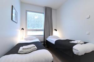 two beds in a room with a window at Forenom Aparthotel Tampere Kaleva in Tampere