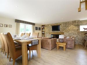 a living room with a table and a couch and a fireplace at Old Groom's Cottage in Witney