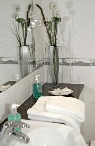 a bathroom with a sink and two vases with flowers at The Long Range in Budleigh Salterton