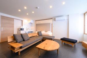 un soggiorno con divano e letto di BEYOND HOTEL Takayama 3rd a Takayama