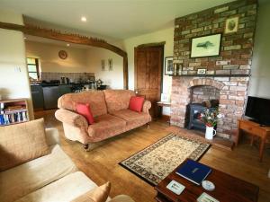 a living room with a couch and a fireplace at The Piggery in Woolaston