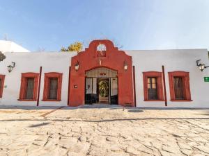 Hacienda Del Angel في باراس دي لا فونتي: مبنى احمر وبيض مع مدخل كبير