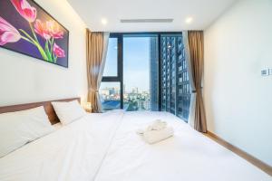 ハノイにあるBOM HOMES- VINHOMES METROPOLIS-Service Apartmentの窓のある大きな白いベッドのある寝室 +64枚の写真