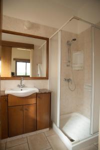 ein Bad mit einem Waschbecken und einer Dusche in der Unterkunft Villa Natasha in Coral Bay